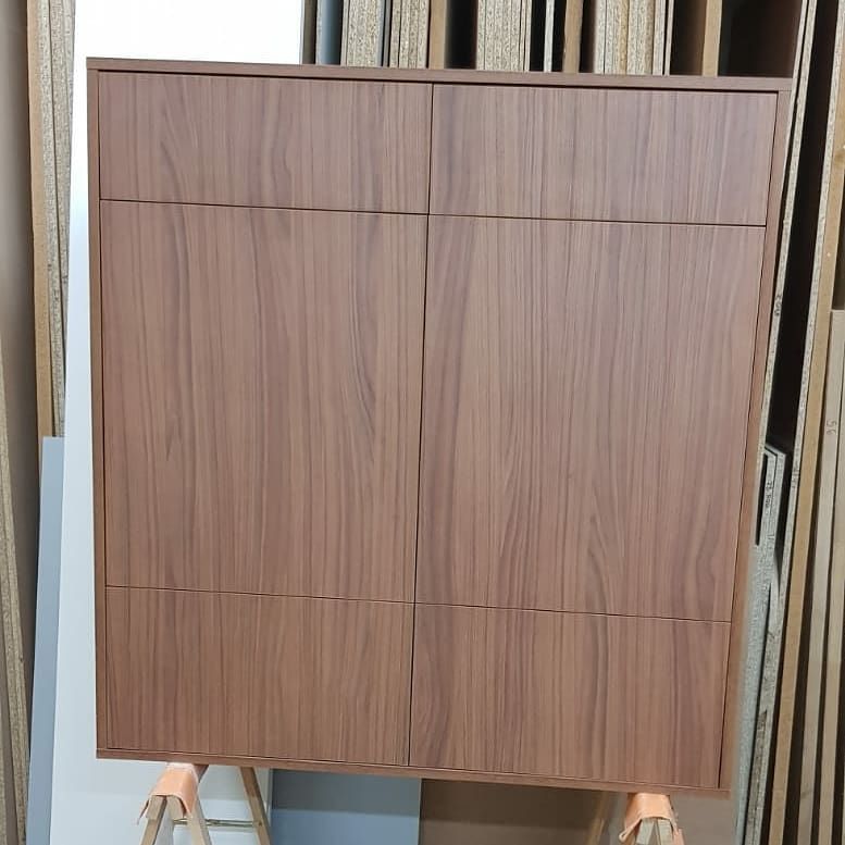 Armario de madera de color marrón con cuatro puertas, montado sobre caballetes de color naranja.