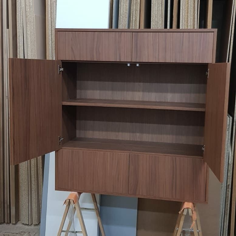 Mueble de madera con puertas abiertas y estantes, montado sobre caballetes.