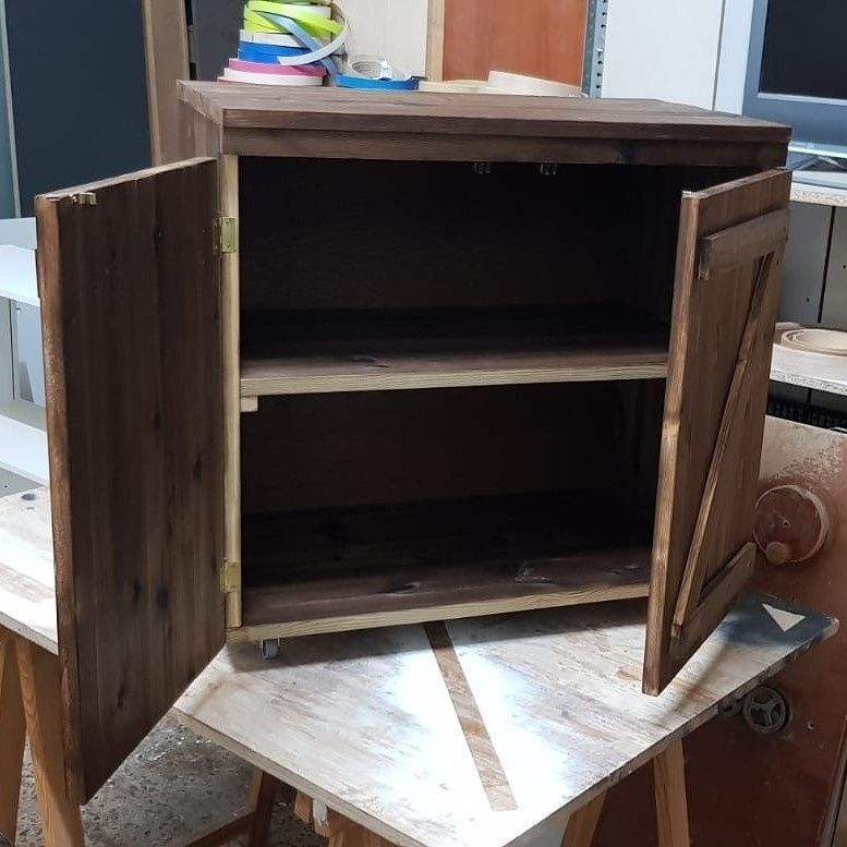 Armario de madera con dos puertas que se abren y dejan ver dos estantes. Madera marrón oscuro.