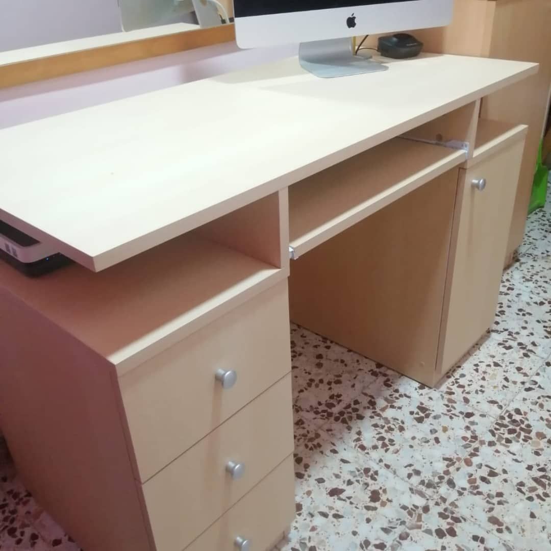 Escritorio color bronce con computadora, cajones y armario.