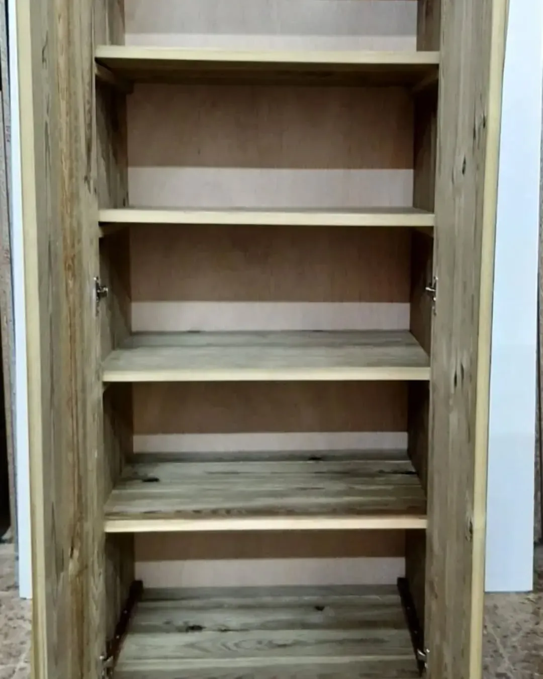 Mueble abierto de madera con cuatro estantes, madera color marrón claro, ambiente neutro.