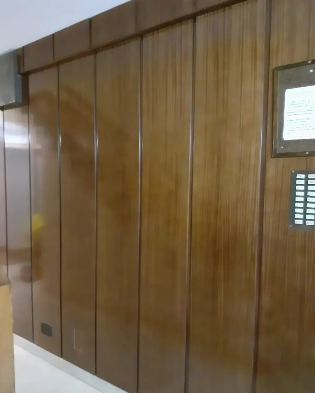 Pared revestida de madera con ranuras verticales y acabado brillante,