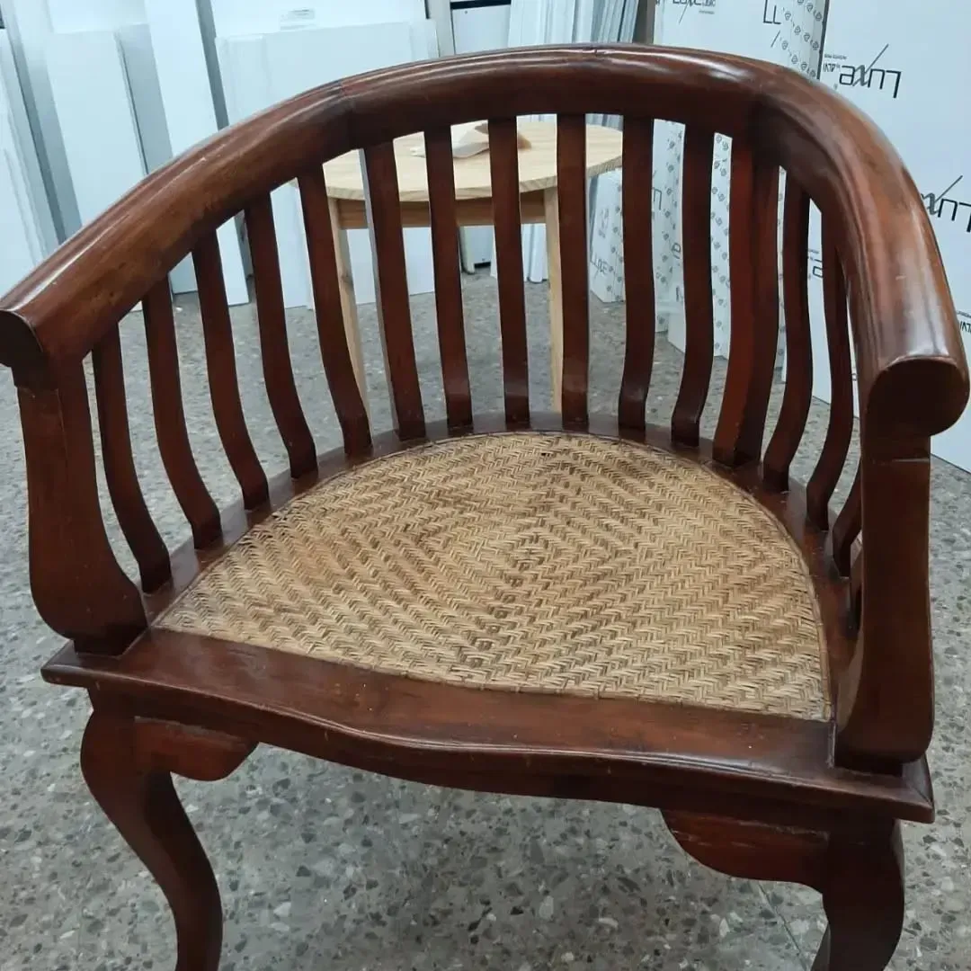 Sillón de madera con respaldo curvado y asiento tejido.