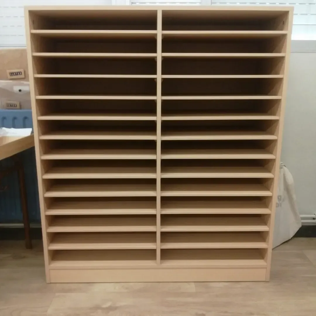 Estantería de madera con numerosos compartimentos horizontales, apoyada sobre una pared.