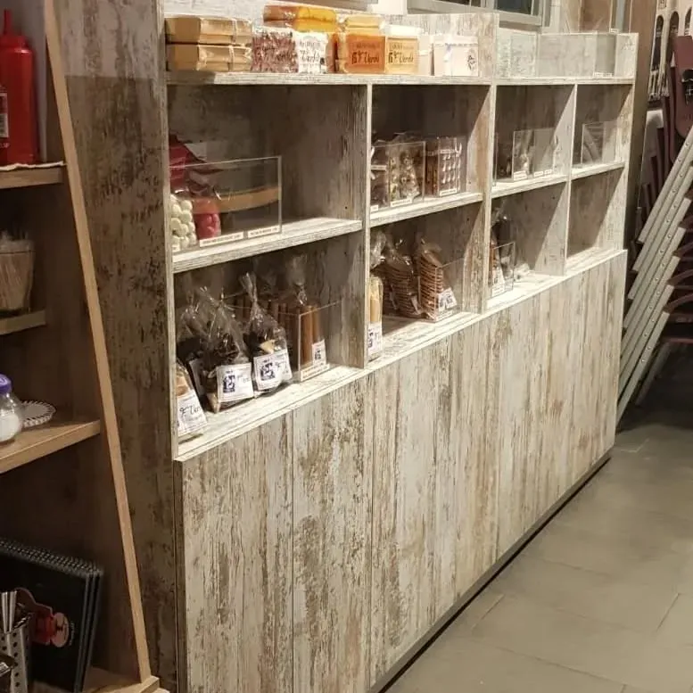Estantes de madera que muestran diversos productos alimenticios en una tienda.