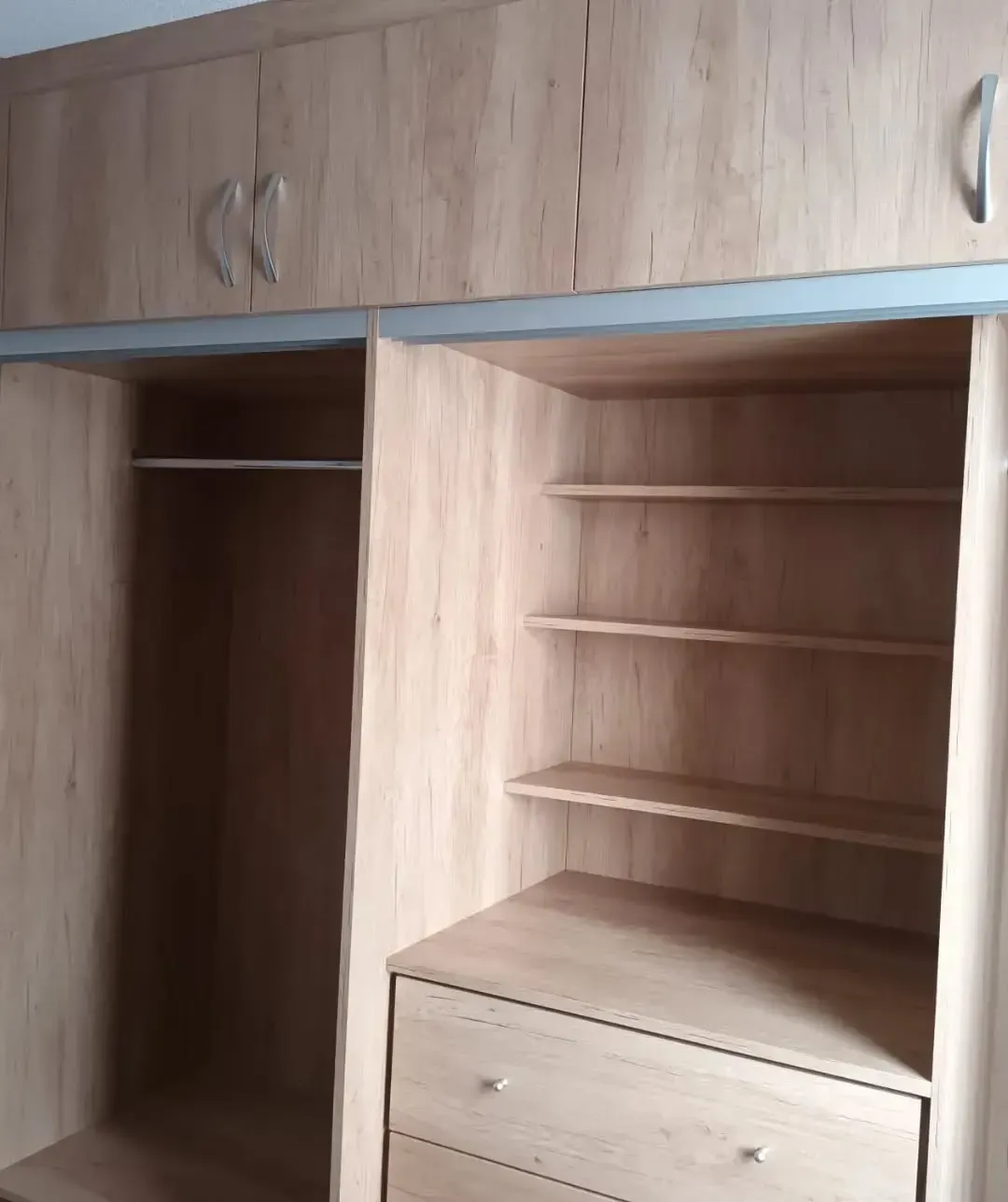 Armario de madera con puertas correderas y estantes.