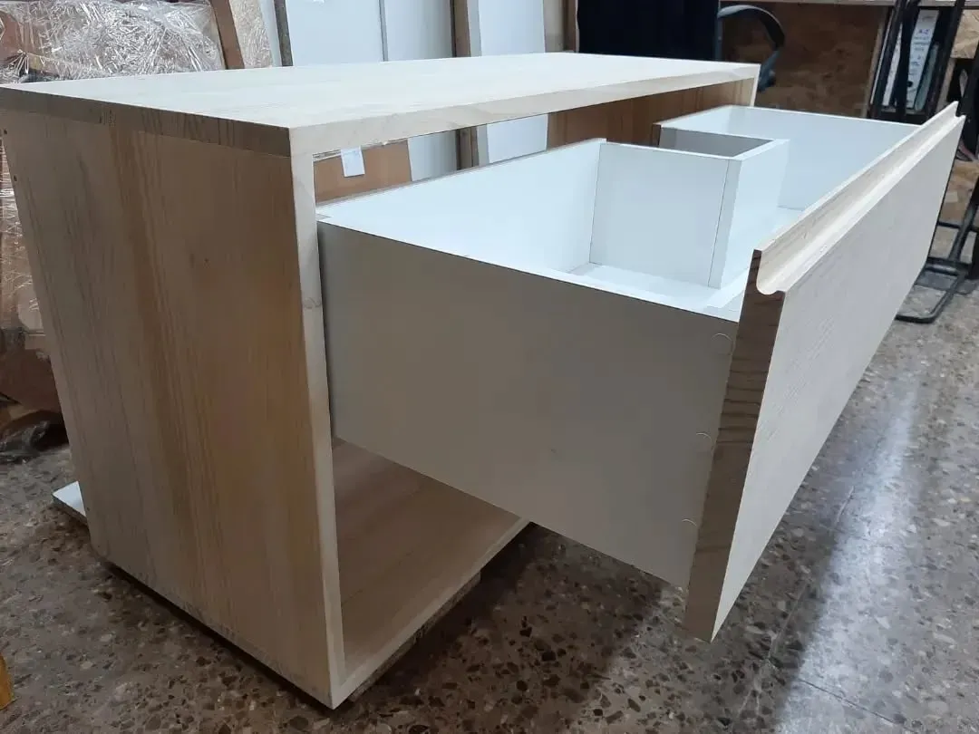 Mueble de madera con cajón abierto, interior blanco y organizador incorporado.