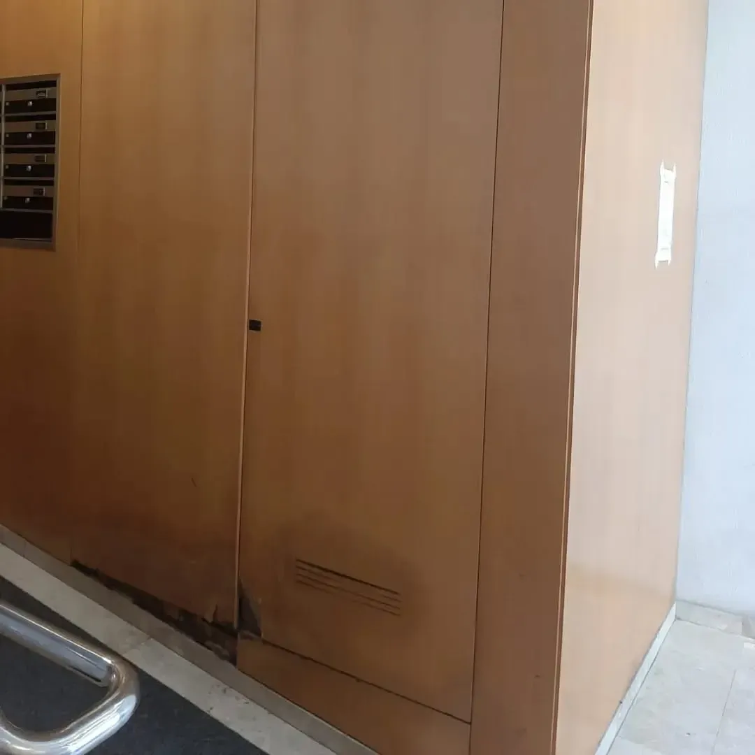 Paneles de madera de color marrón con una pequeña entrada y una marca blanca.