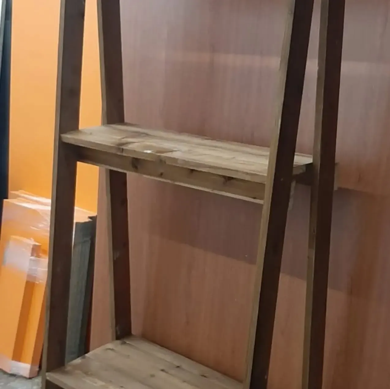 Estantería inclinada de madera con tres baldas.