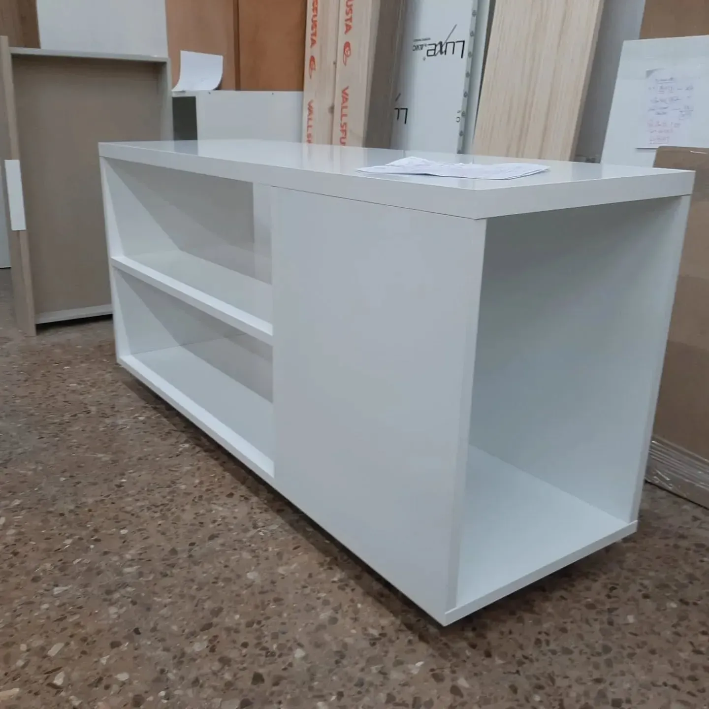 Estantería rectangular de color blanco con compartimento abierto y dos estantes.