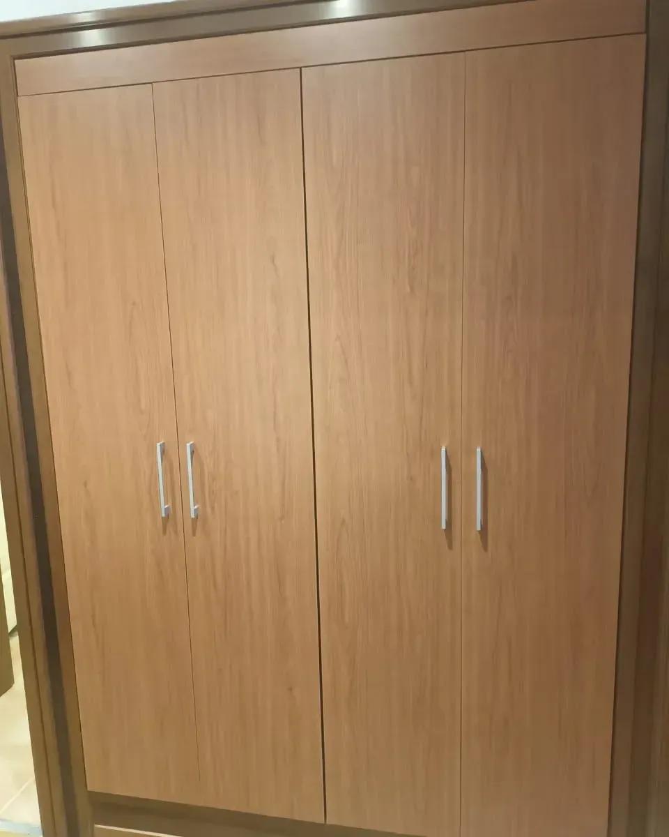 Armario de madera de cuatro puertas con tiradores plateados.