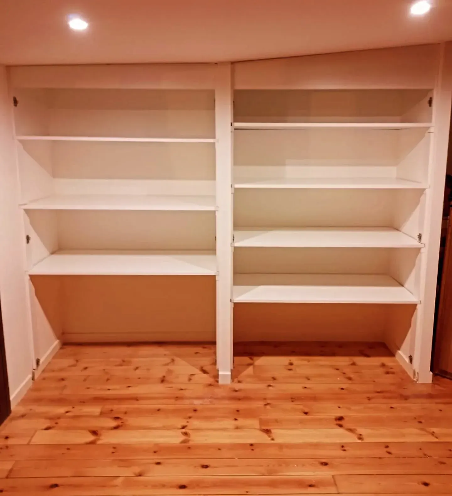 Estanterías blancas empotradas con cuatro estantes cada una