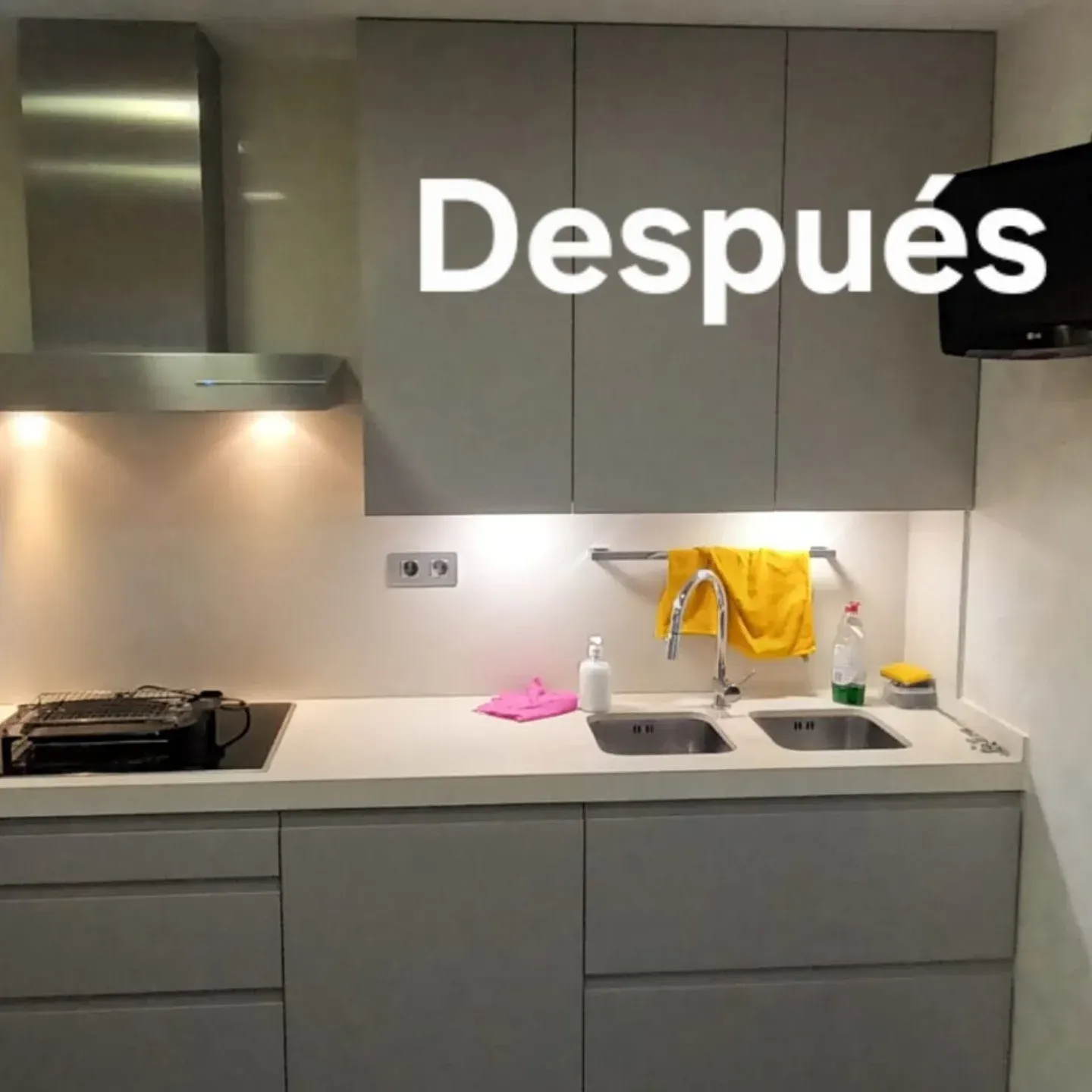 Cocina moderna con gabinetes grises, encimera y campana extractora de acero inoxidable, etiquetada 