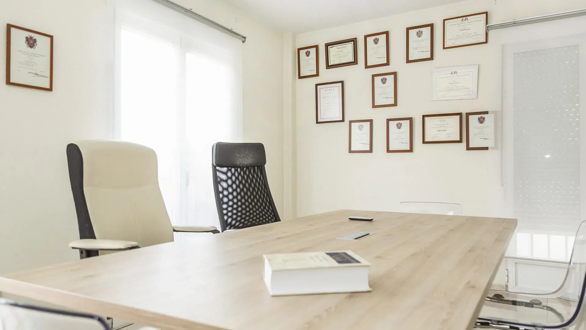 Una sala de conferencias con una mesa y sillas de madera y un libro sobre la mesa.