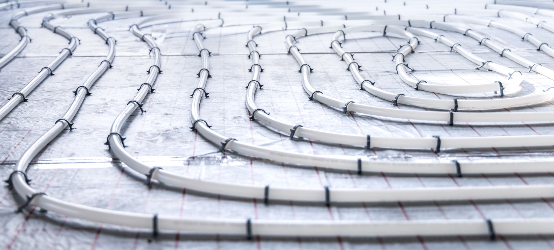 Tuyaux pour système de chauffage au sol sur une surface en béton.