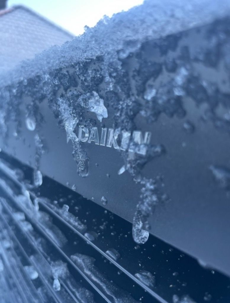 Unité de climatisation Daikin recouverte de glace et de neige.
