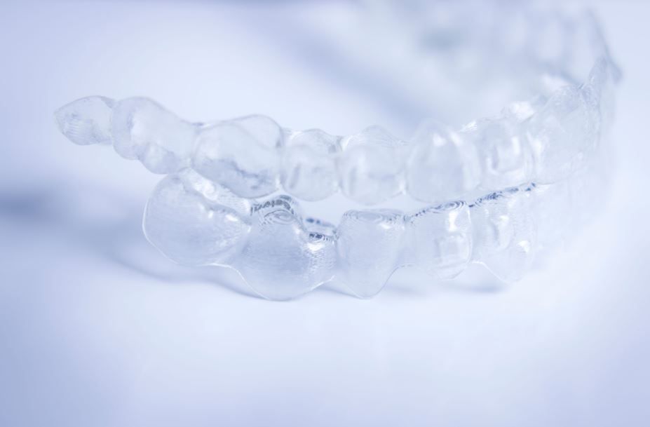 Alineadores dentales transparentes sobre un fondo azul claro