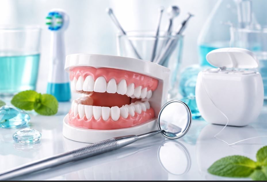 Modelo dental con espejo y cepillo de dientes en un baño luminoso.