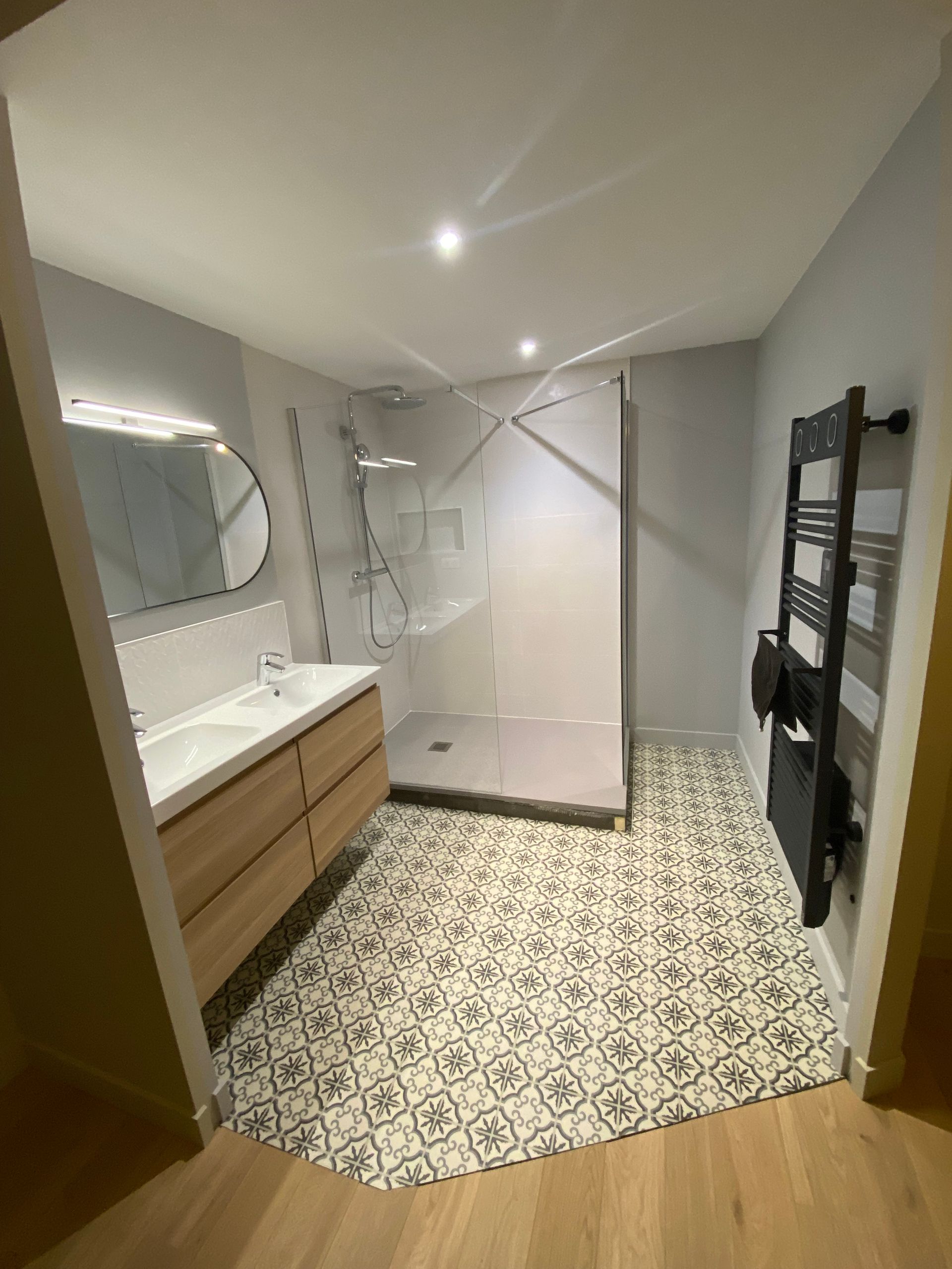 Double vasque, cabine de douche, sèche-serviettes et carrelage au sol