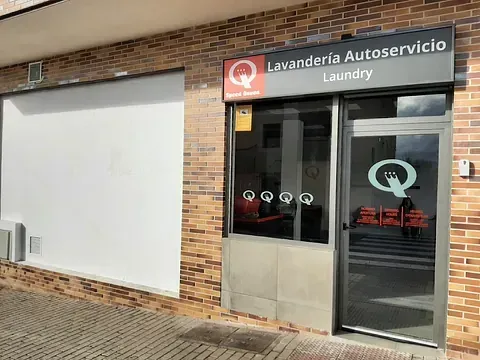Un edificio de ladrillos con un cartel que dice lavandería.