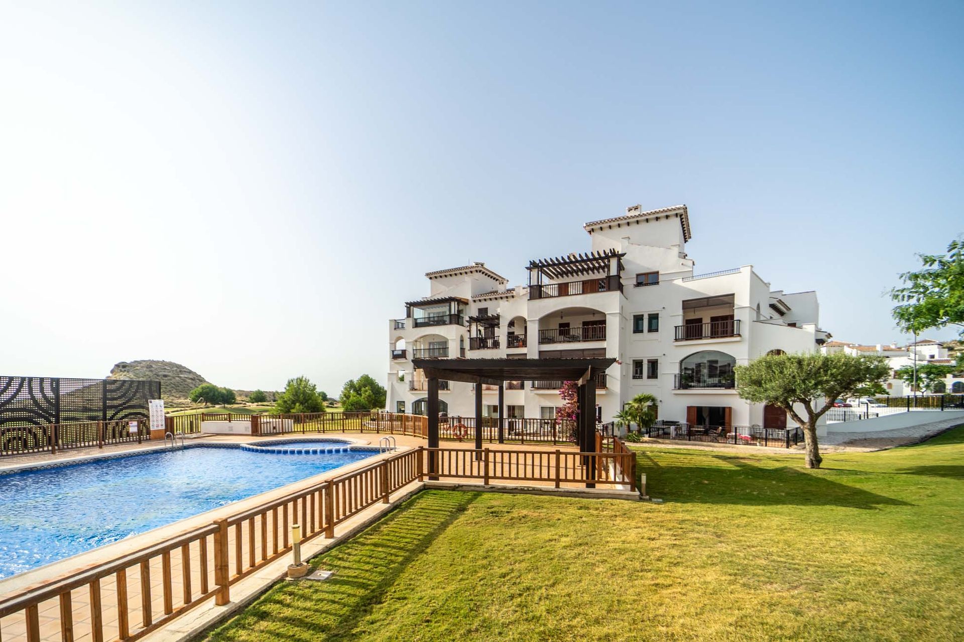 A large white building with a swimming pool in front of it