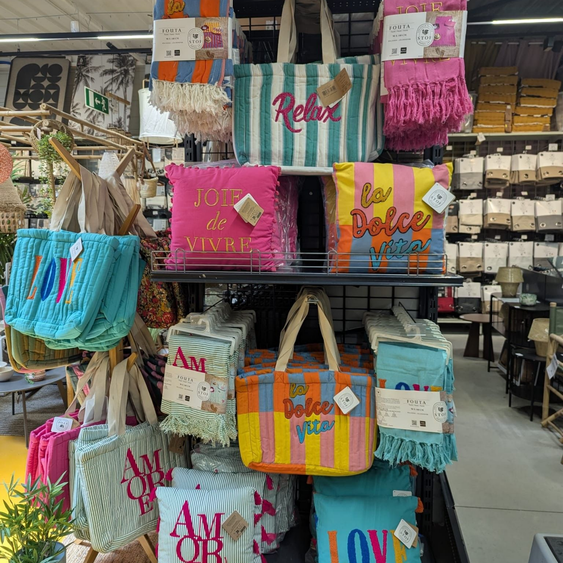 Des sacs à rayures colorées sont présentés sur une étagère dans un rayon de magasin.