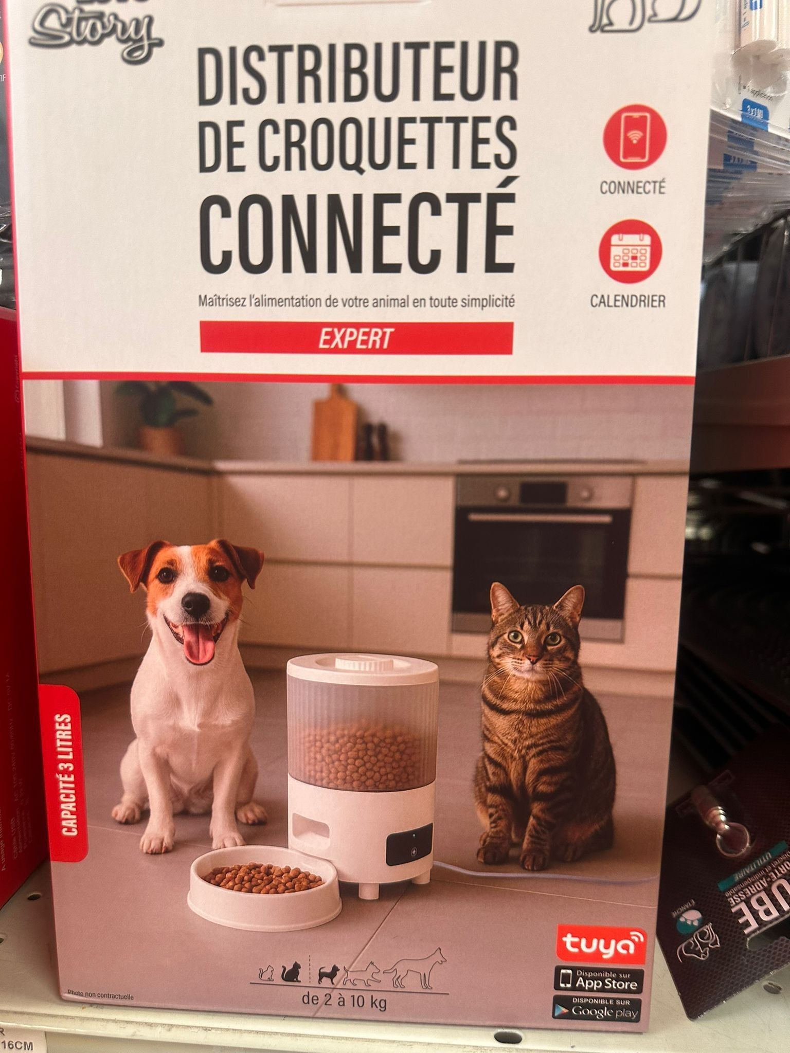 Boîte pour distributeur automatique connecté de croquettes, avec un chien et un chat sur le carton.