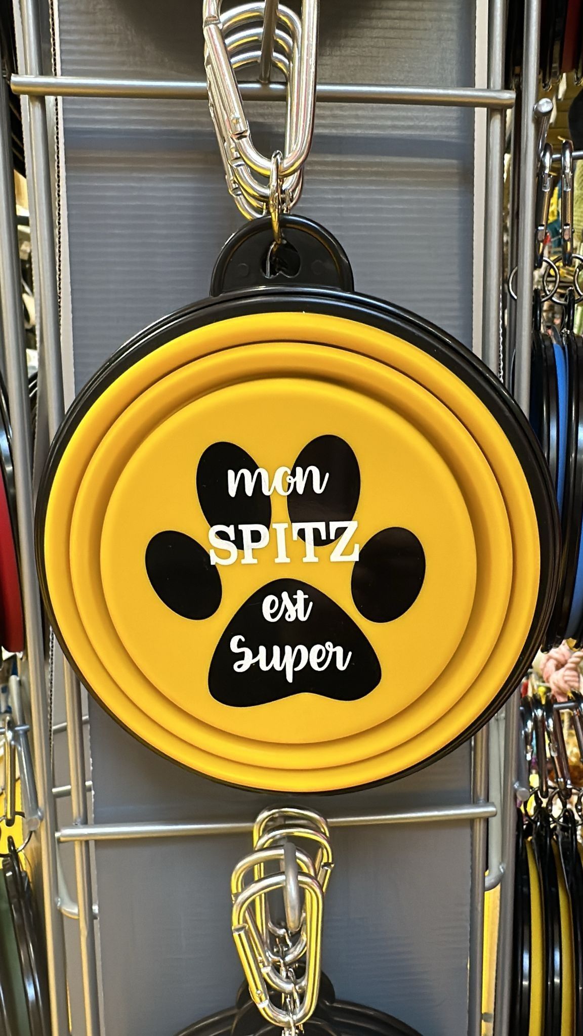 Disque suspendu rond jaune et noir avec l'inscription SPITZ sur un présentoir.