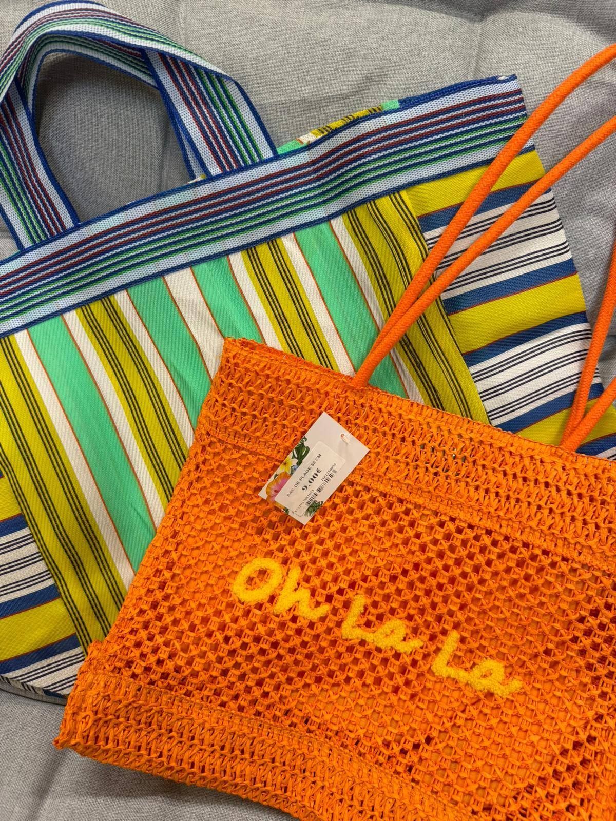 Deux sacs rayés, dont un sac en filet orange, se chevauchant sur une surface grise.