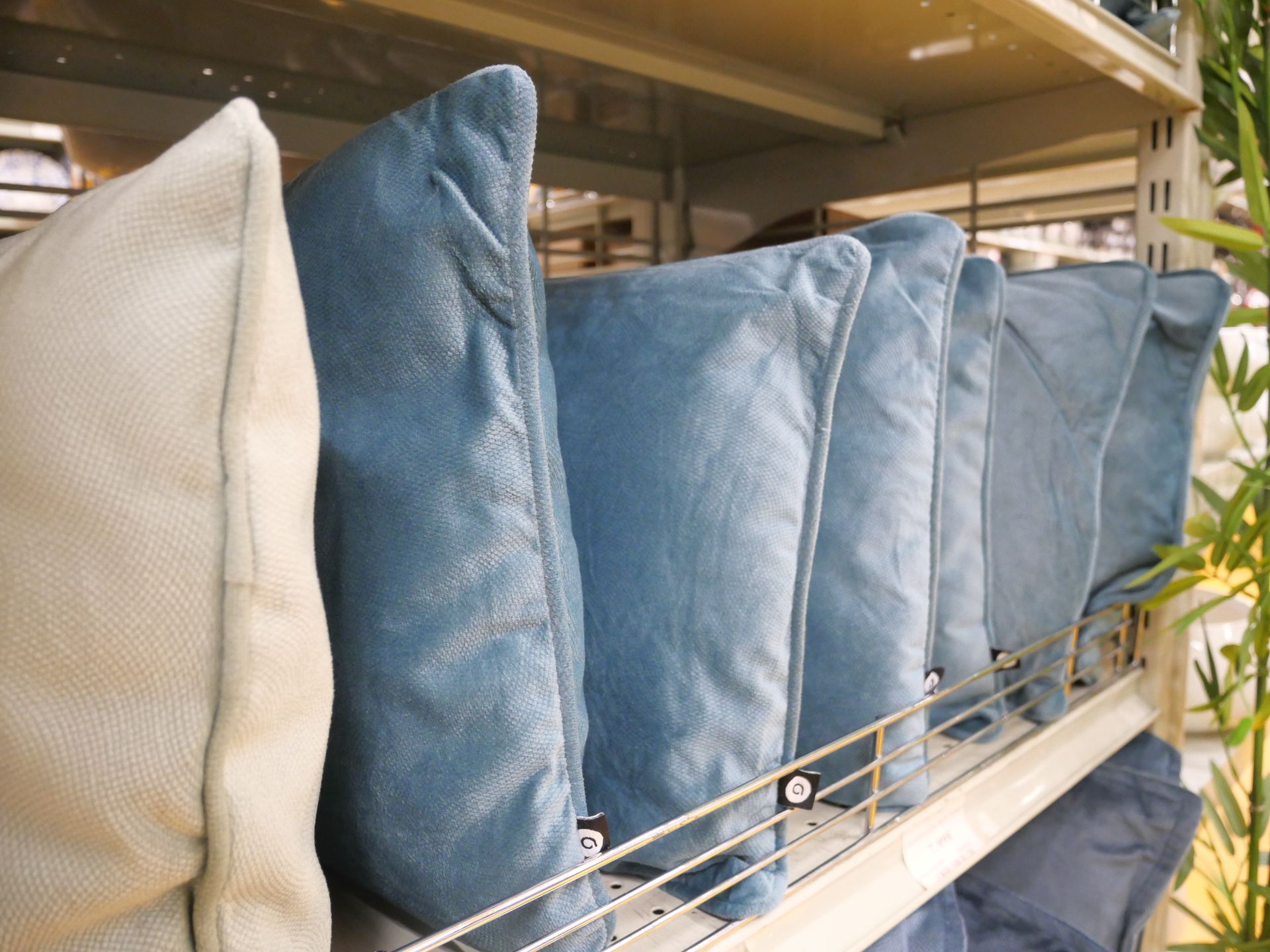 Des coussins bleus et blancs alignés sur une étagère de magasin