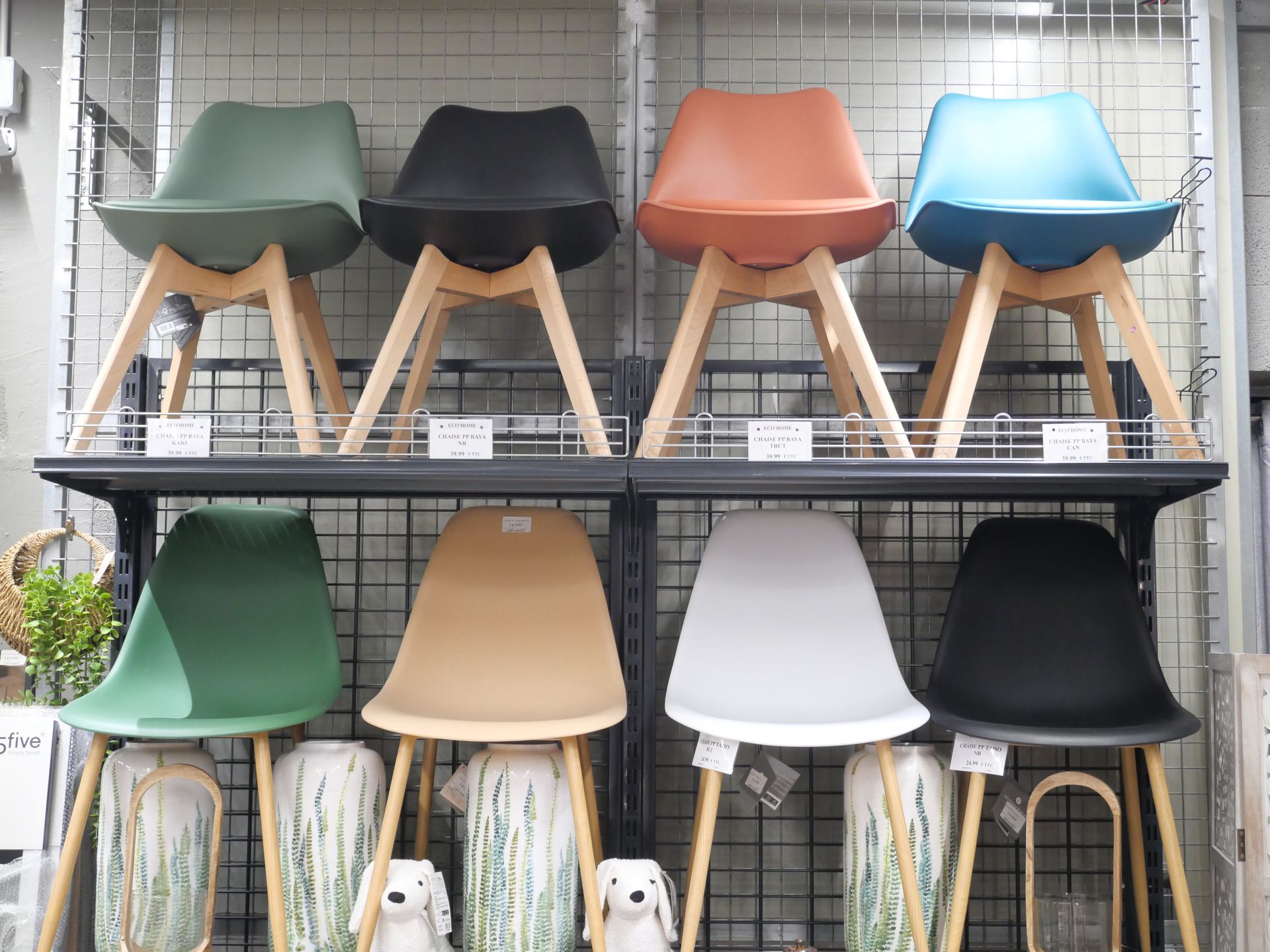 Des rangées de chaises modernes et colorées sont exposées sur des étagères dans un magasin.