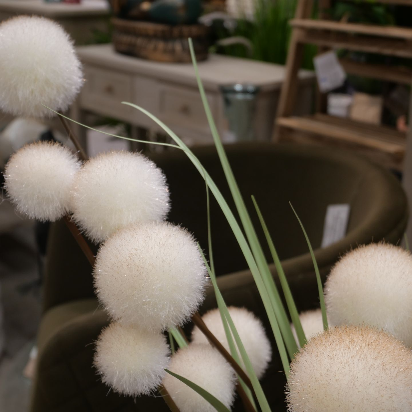 Fausses fleurs blanches duveteuses en forme de pompons avec des tiges vertes.