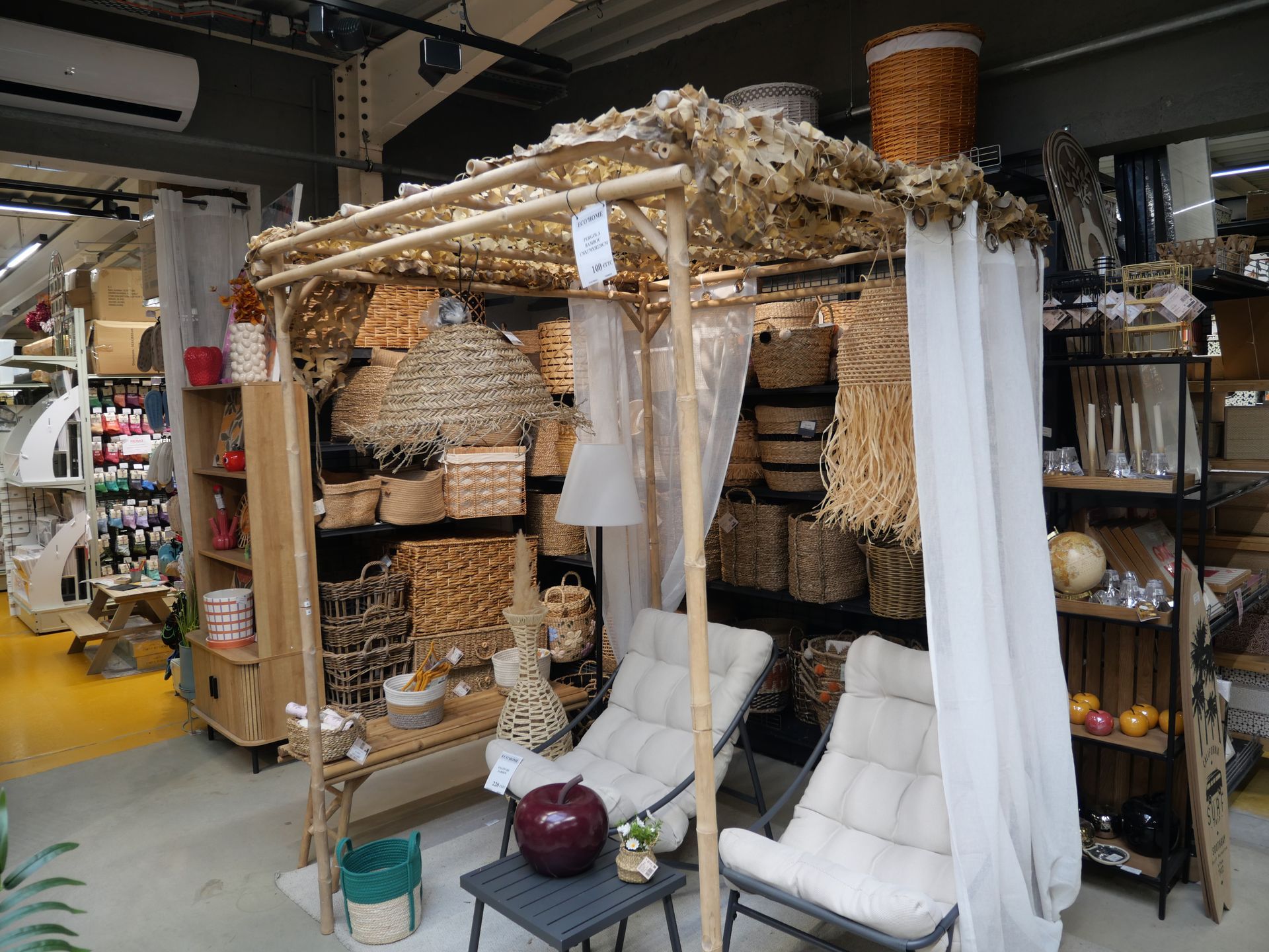 Des étagères contenant des paniers, des articles tissés avec une pergola en bois au milieu.