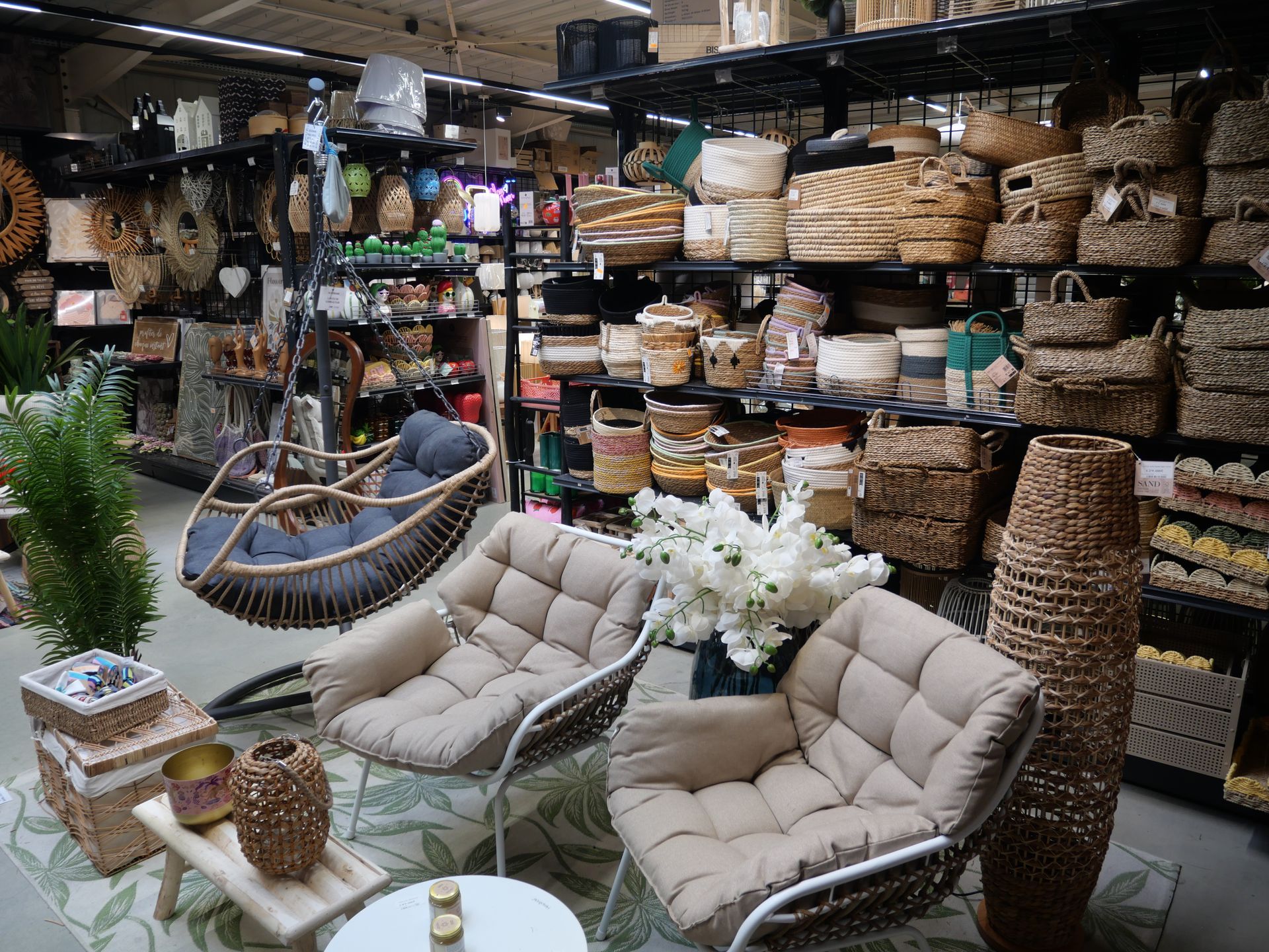 Mobilier et décoration intérieure chaleureuse présentant des chaises en osier, des coussins et des paniers tressés.