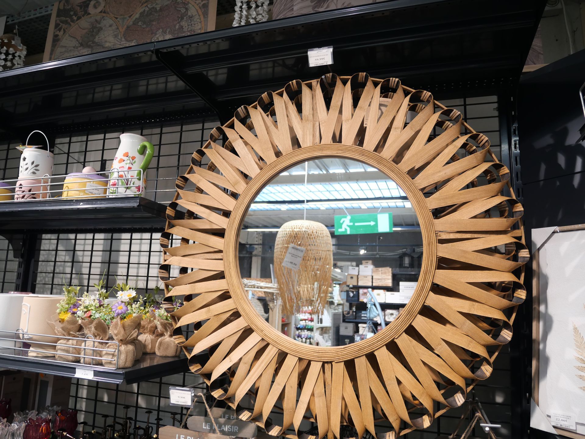Miroir rond en bois effet soleil sur une étagère.