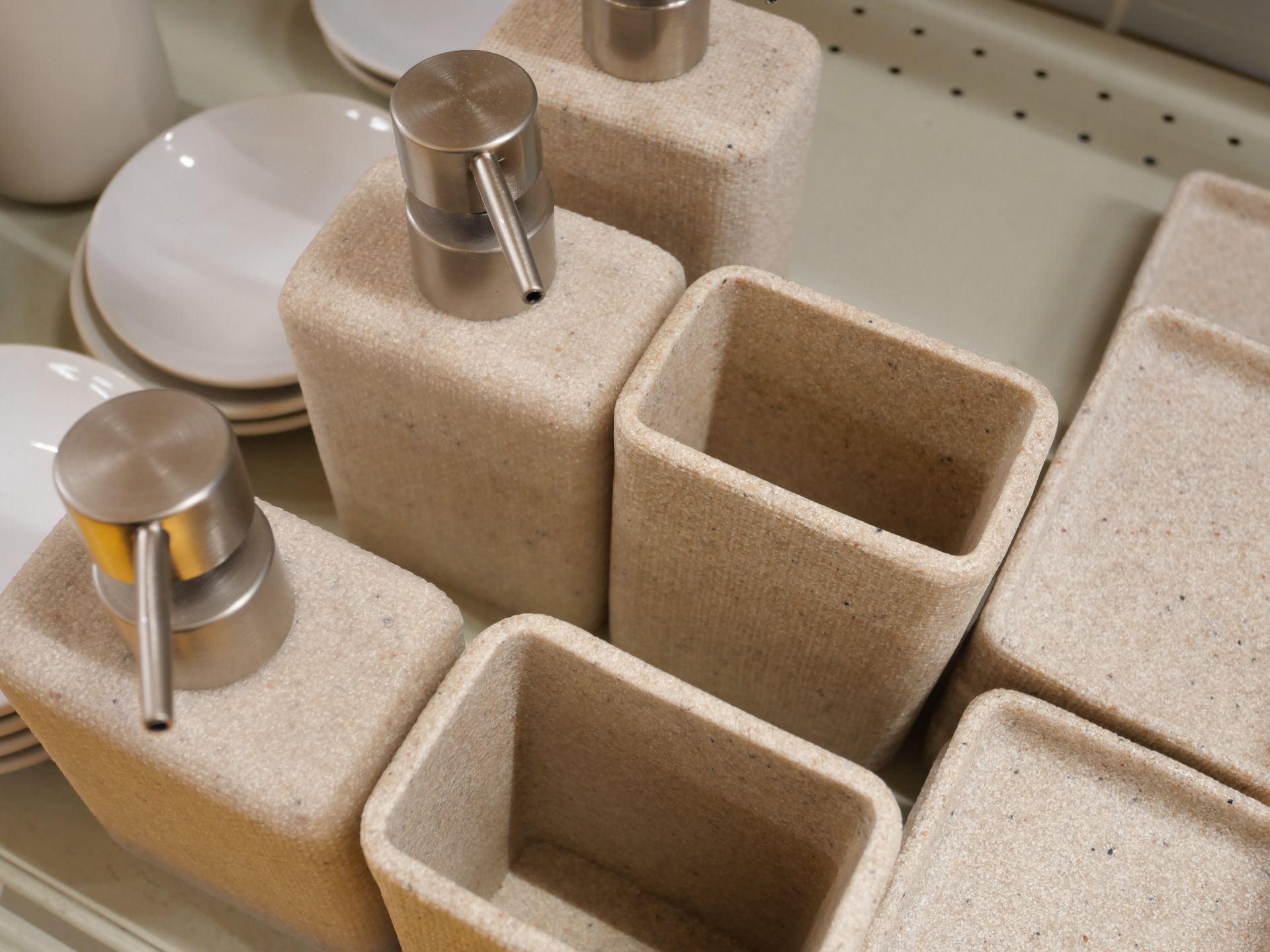 Des distributeurs et porte-savons beiges pour salle de bains.