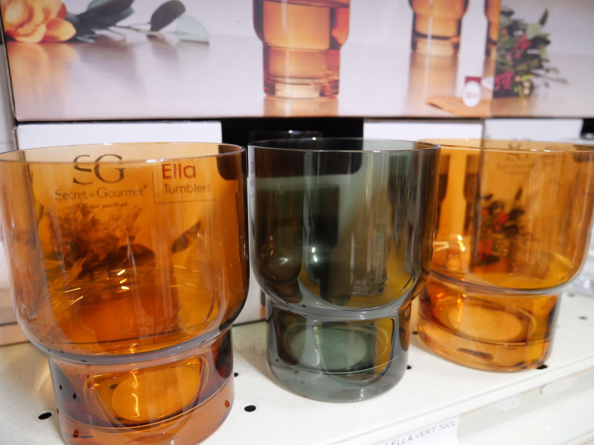 Trois verres en verre ambré et vert sur une étagère.
