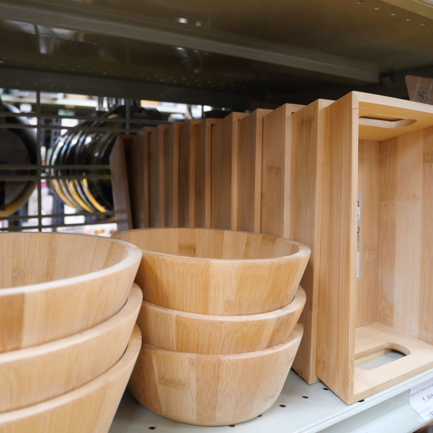 Des bols et des plateaux en bois empilés sur une étagère de magasin