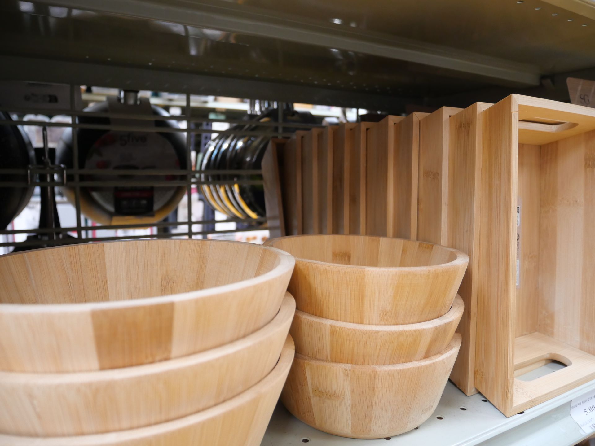 Des bols et des paniers en bois empilés sur des étagères dans un magasin