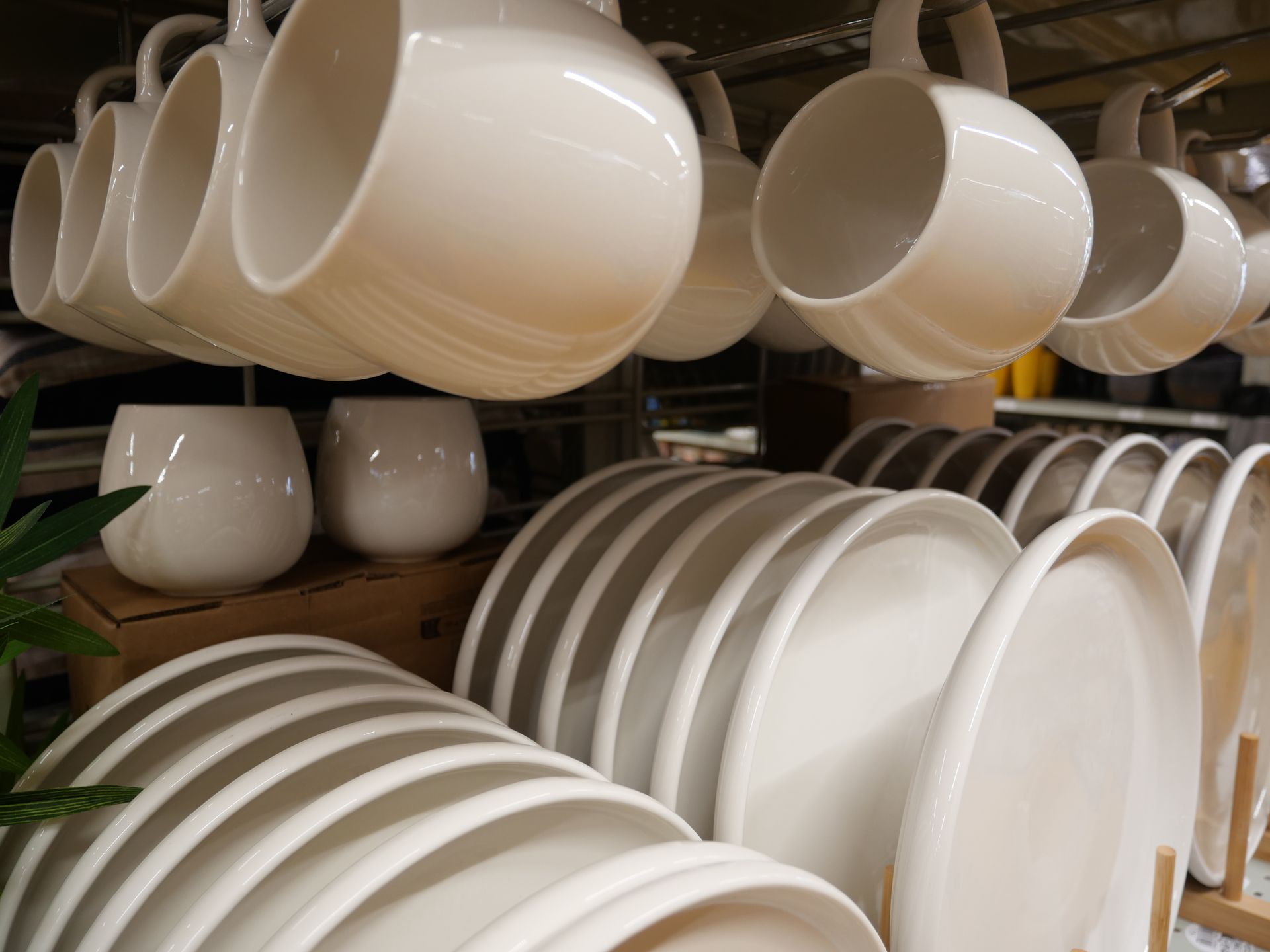 Tasses et soucoupes empilées sur des étagères dans les rayons du magasin.