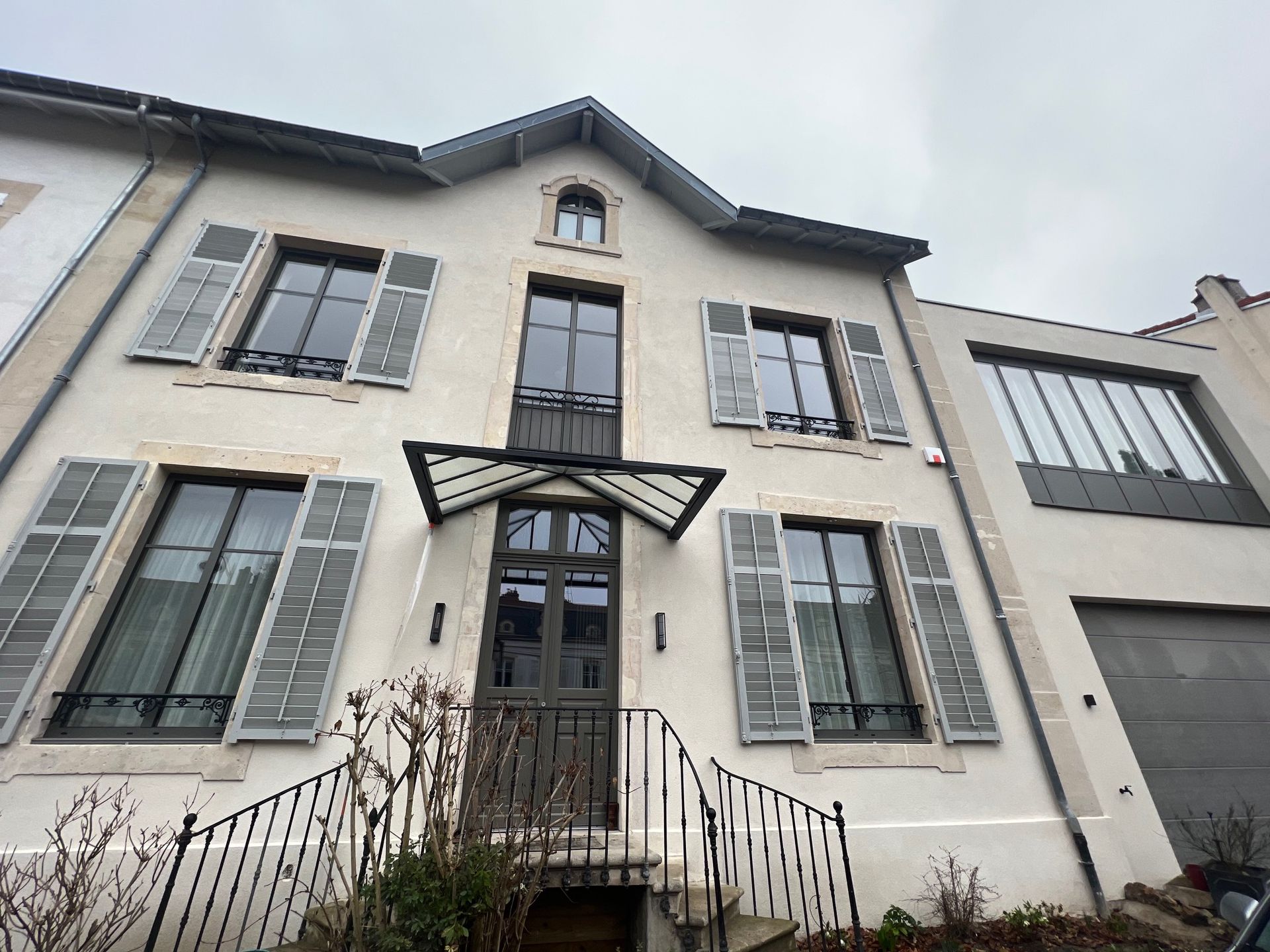 Porte à cadre blanc avec panneaux de verre et vue sur le jardin, laissant entrer la lumière naturelle.