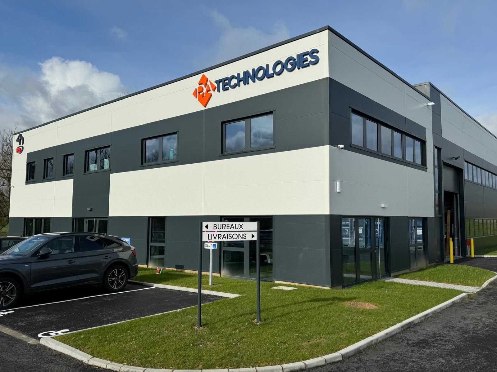 Double porte en bois brun à panneaux rectangulaires et imposte vitrée, dans un bâtiment en pierre claire.