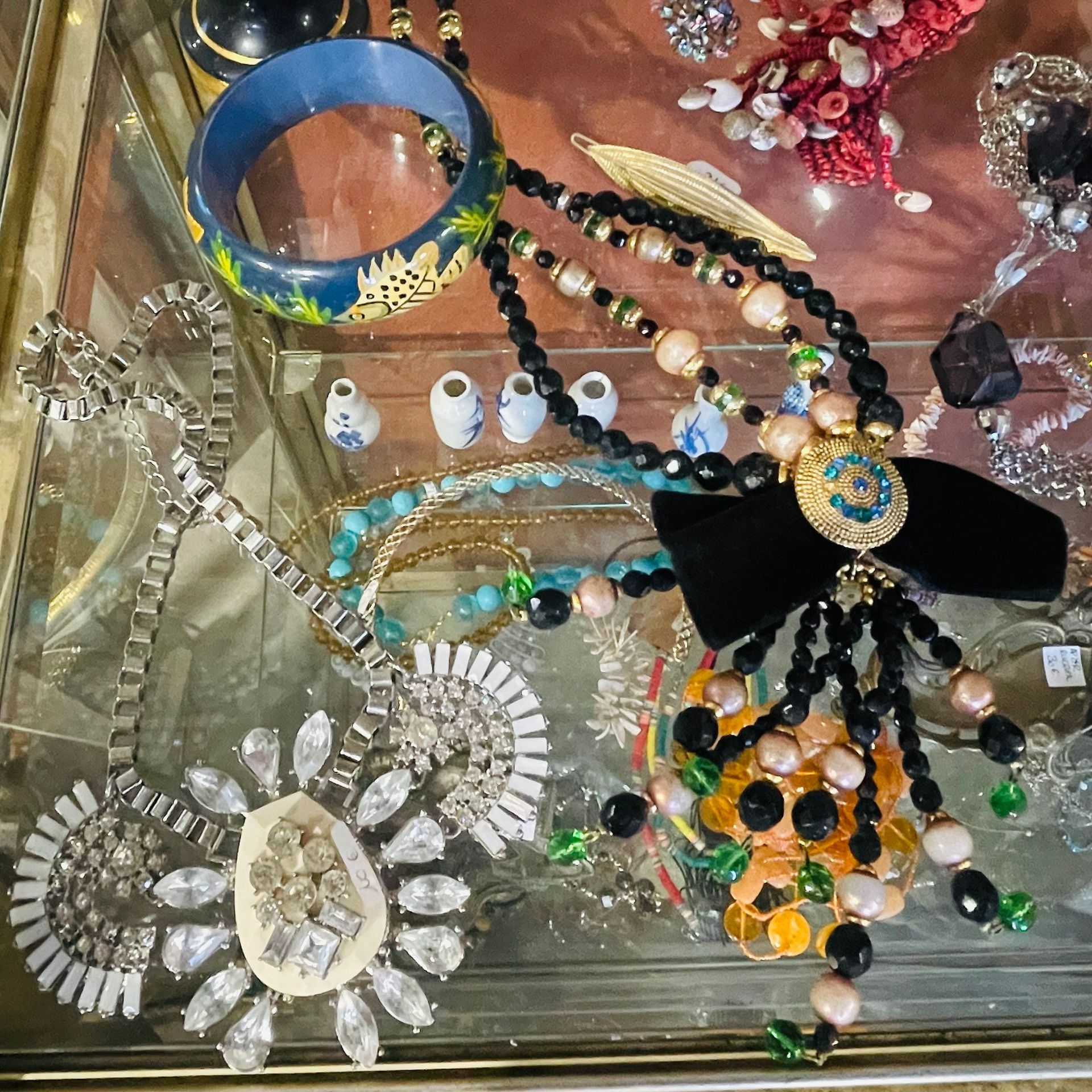 Bijoux vintages posés sur un plateau en verre