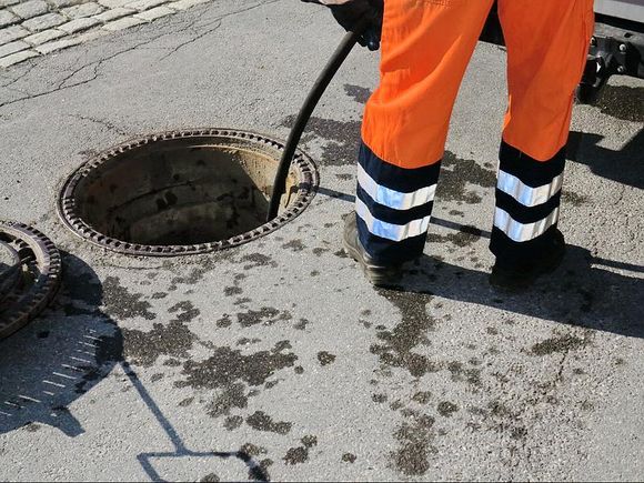 Égoutier nettoyant le tuyau dans la rue