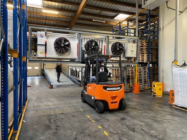 Chariot élévateur orange soulevant des turbines