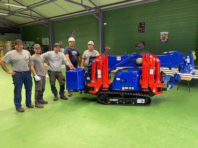 Équipe de PromarHandling posant à côté d'une mini-grue