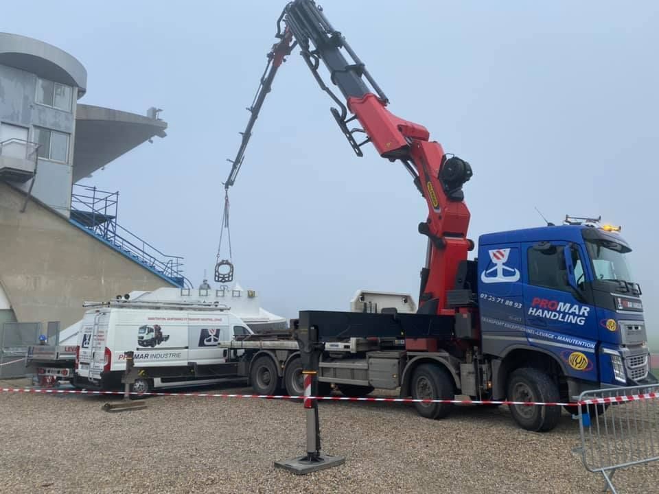 Camion à bras de PromarHandling soulevant une pièce métallique au dessus d'une camionnette