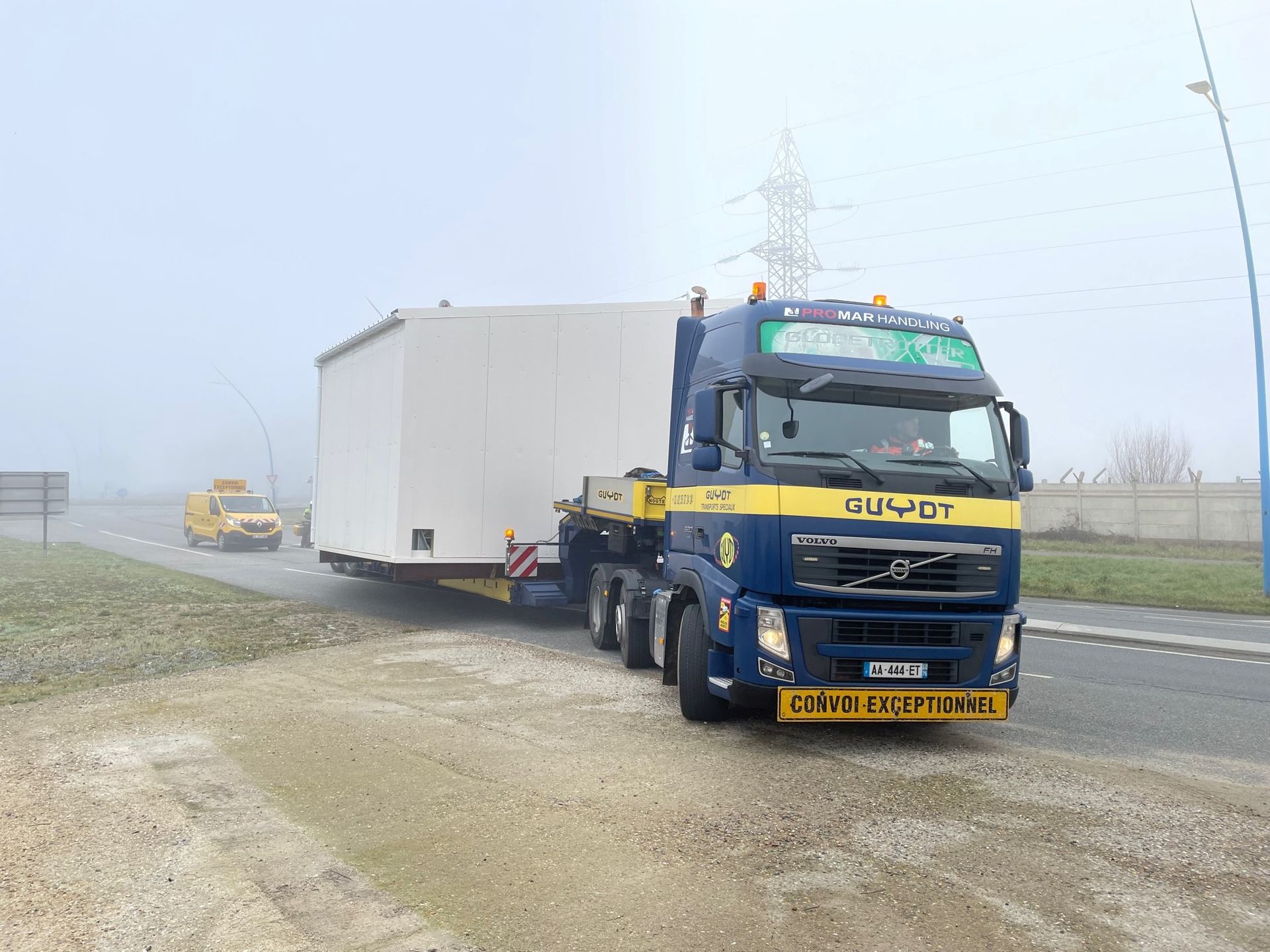 Convoi exceptionnel avec camion bleu et voiture pilote