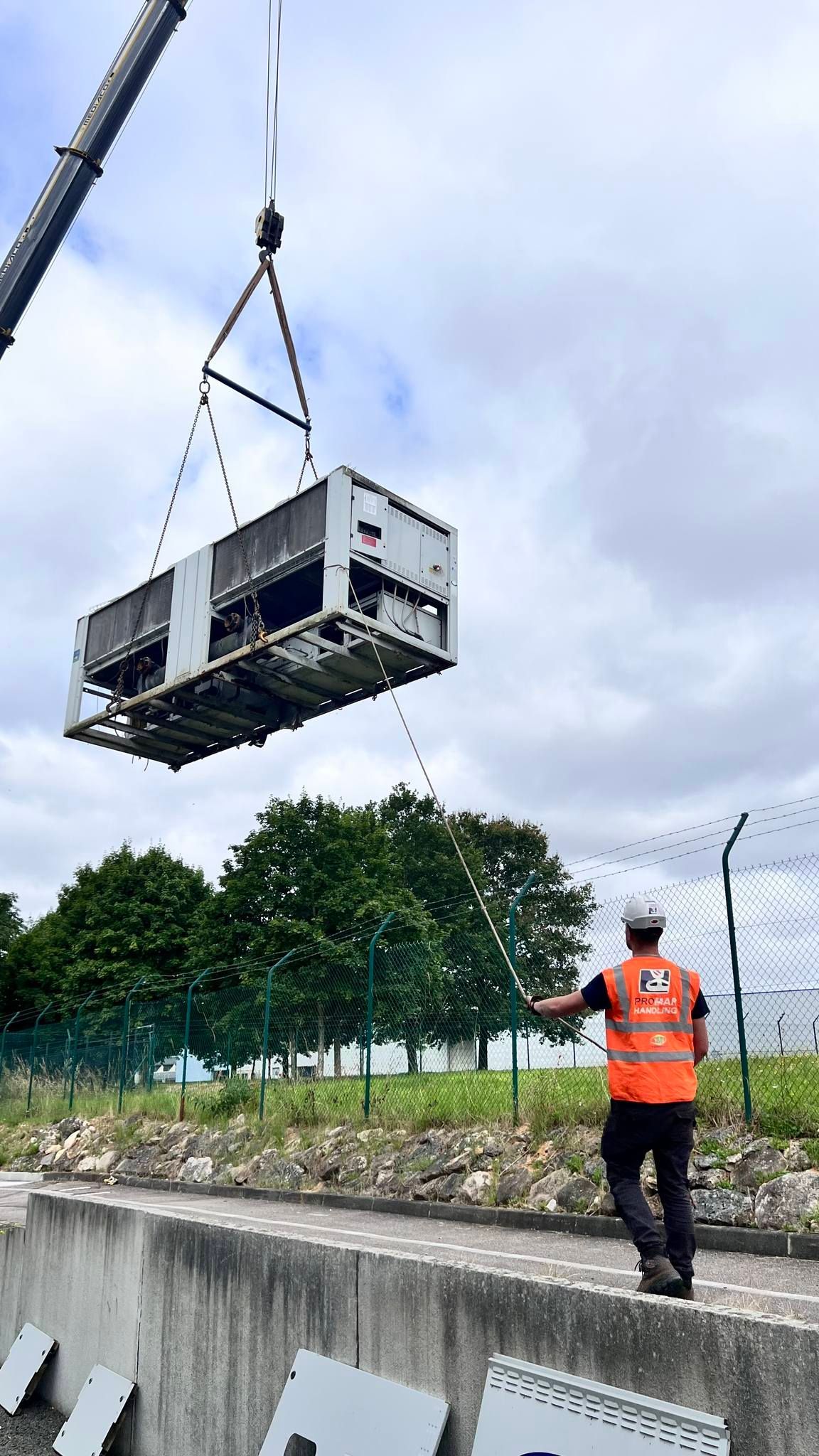 Machine industrielle mécanique suspendue par une grue en extérieur