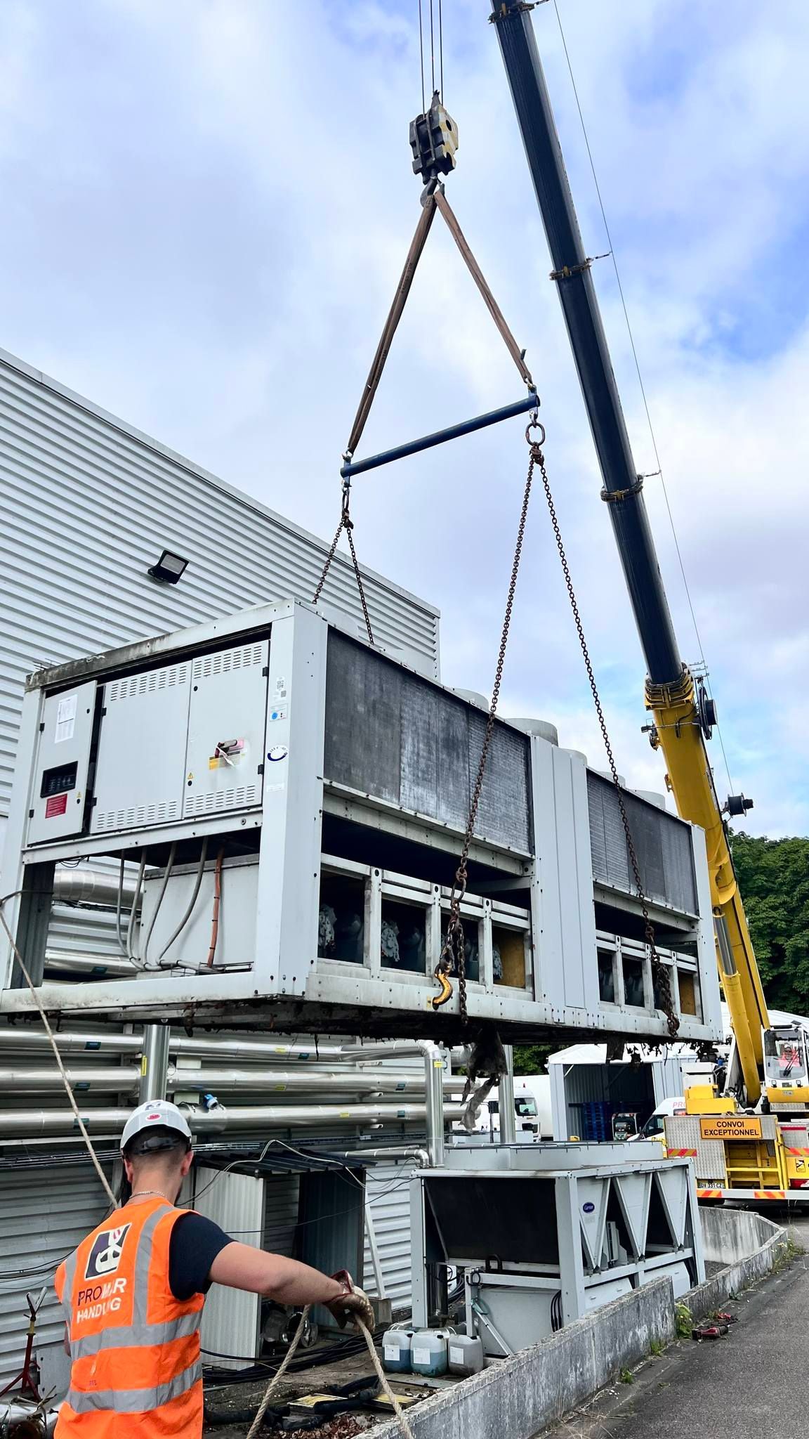 Bras de grue soulevant une machine industrielle